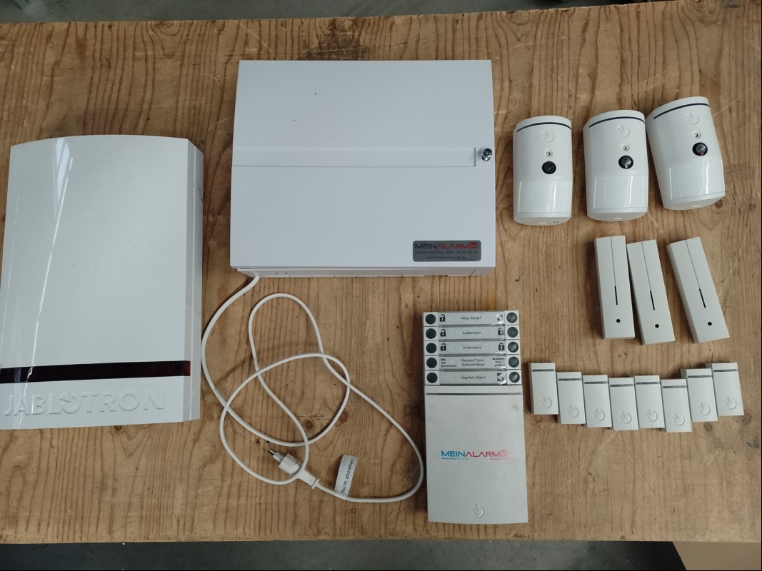 Teile aus Jablotron Alarmanlage bestehend aus: 1x Jablotron JA-103 K Zentrale, Bedienteil JA-154E 3x Funk-Kamera-PIR Bewegungsmelder JA-160PC, 3x Funk-Glasbruchmelder JA-180B, 8x Funk-Magnetkontakt JA-151M und 1x Sirene JA-163A RB, alles ungeprüft...